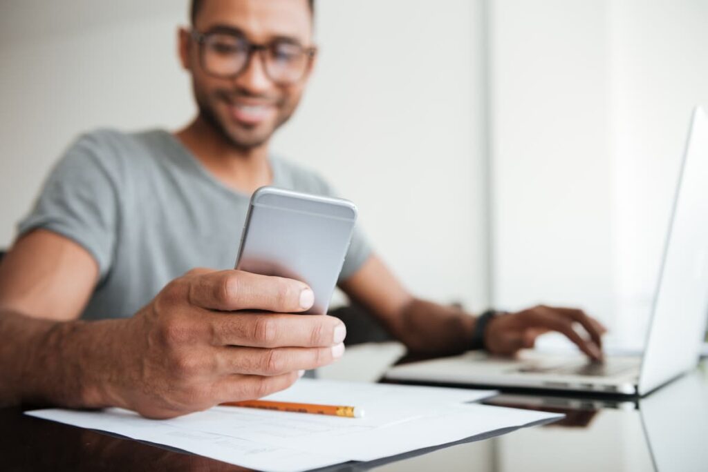 A man reading a group message text from his employer.