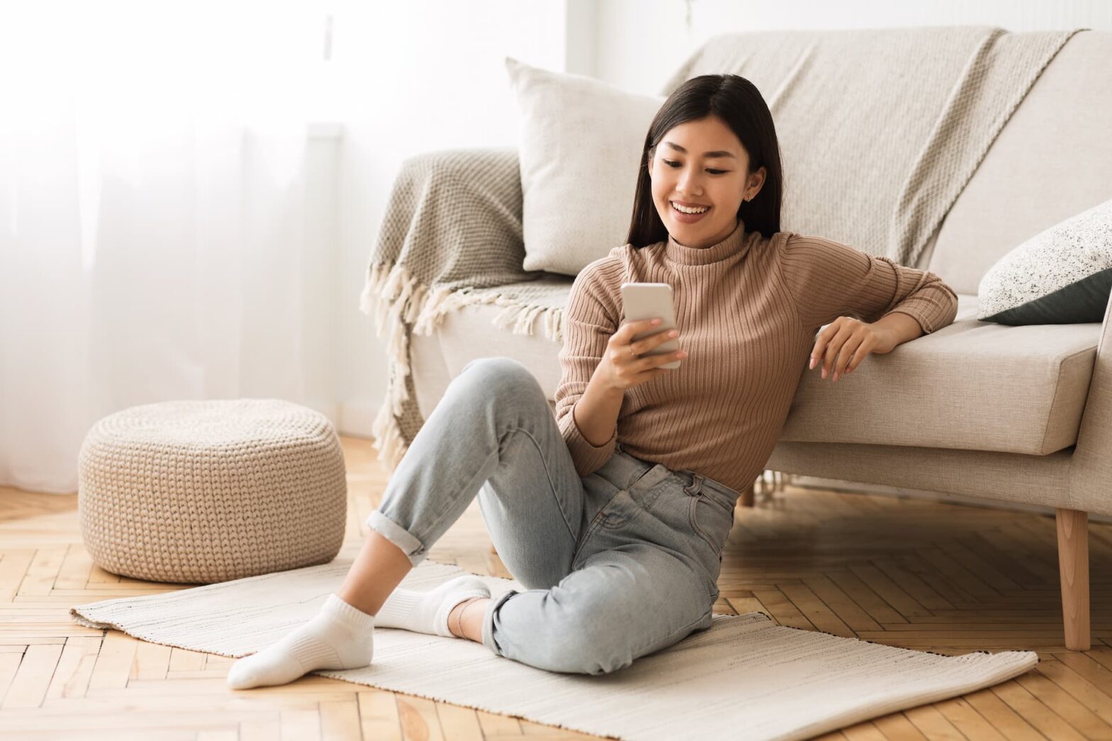A woman texting in her living room.